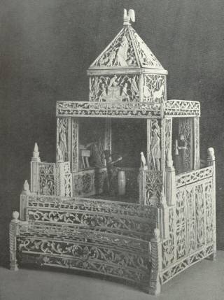 Elaborately Carved Ornamental Design in Bone Work, Representing
a Theatre, with Figures in Carved Bone on the Stage, the Work of
the Norman Cross Prisoners of War.  Height 14 inches, base 9
inches square.  Peterborough Museum